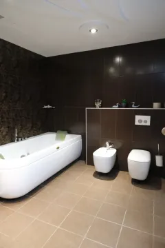 Moderne kupatilo sa kadom, wc šoljom i bideom u braon tonovima. - image 13