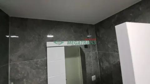 Kupatilo sa tamnim zidnim pločicama i belim vratima. - image 4