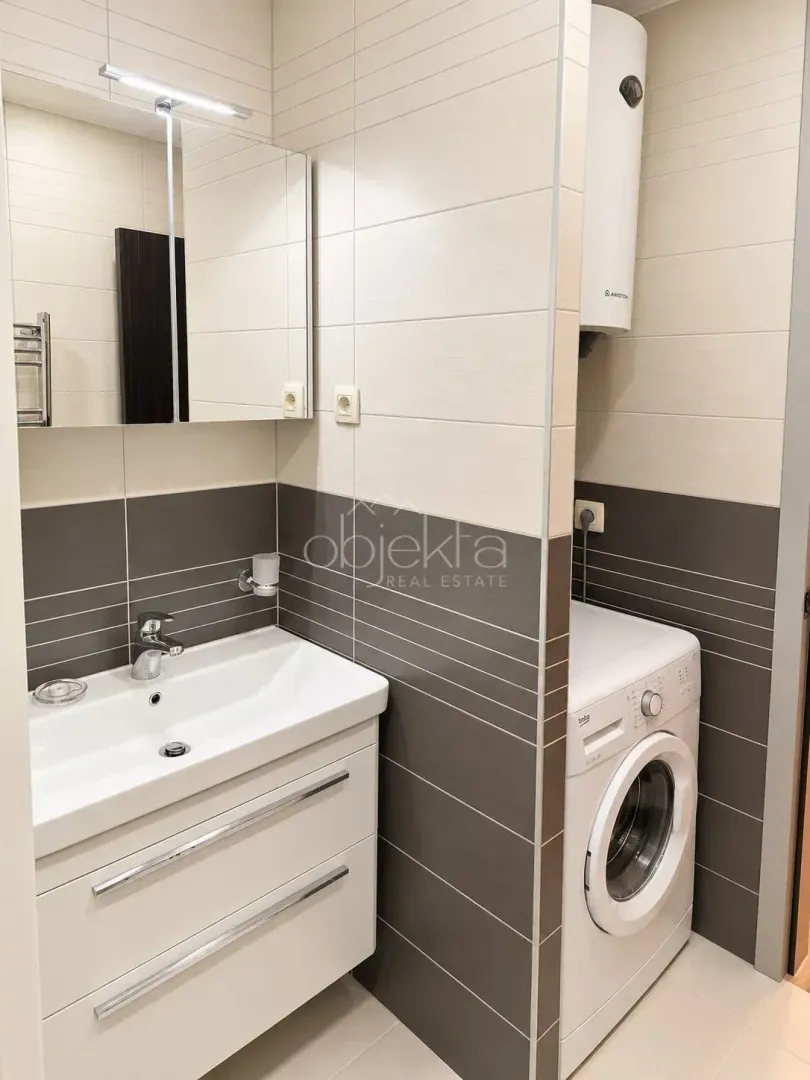 Bathroom with washbasin, mirror and washing machine.