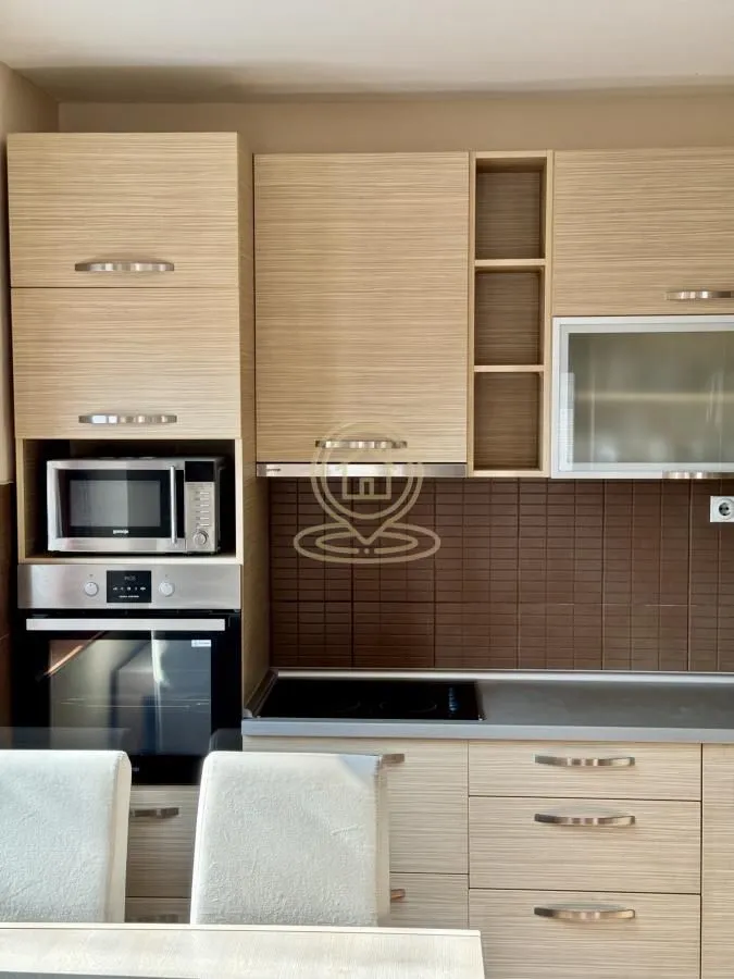 Modern kitchen with wooden cabinets and a built-in oven.