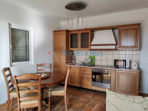 Kuhinja sa drvenim elementima i trpezarijskim stolom sa stolicama. - image 6