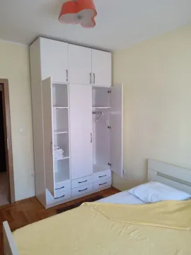 Svijetla spavaća soba sa velikim bijelim ormarom i krevetom. - image 5