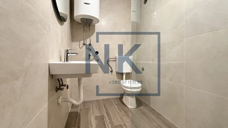 Bathroom equipped with a washbasin, toilet bowl, water heater, and shower enclosure.