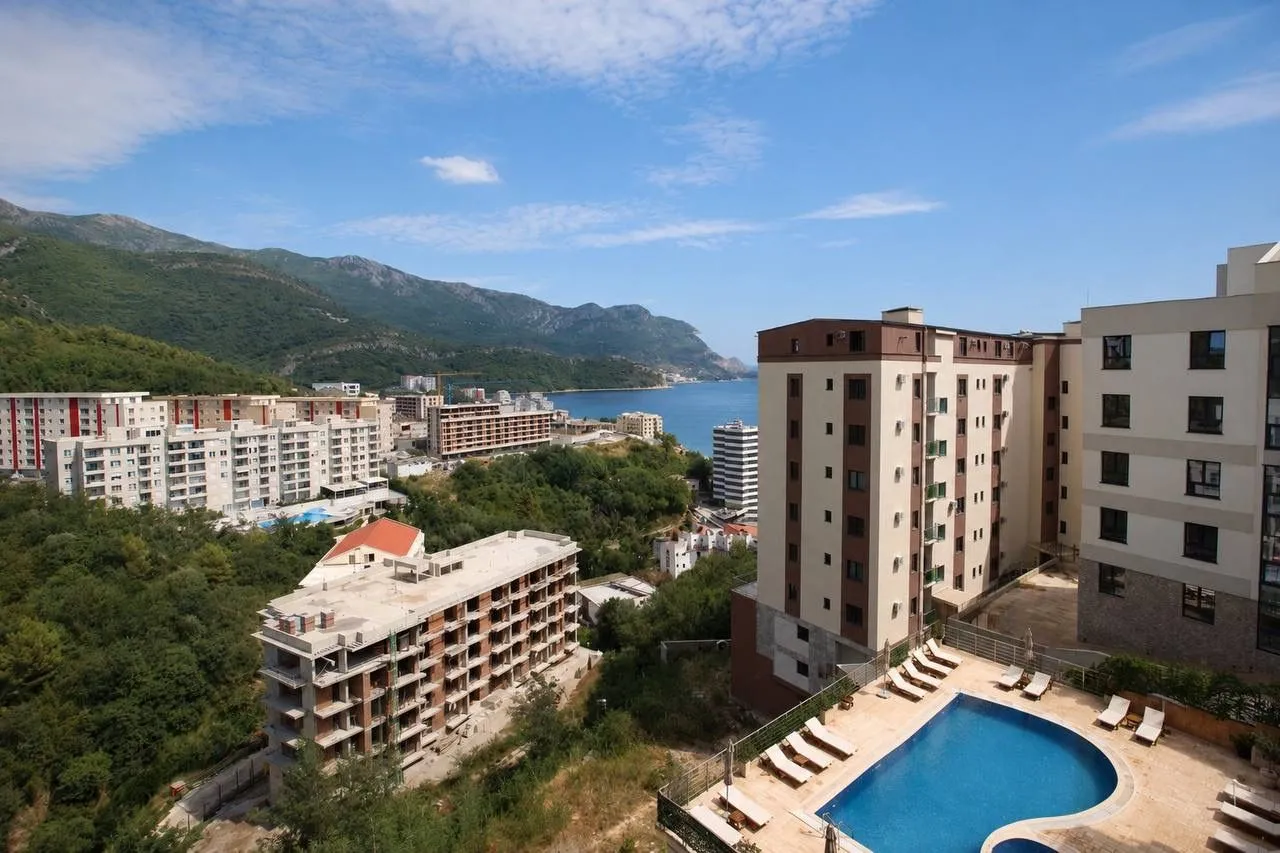 View from the terrace overlooking the neighborhood, swimming pool, and sea.
