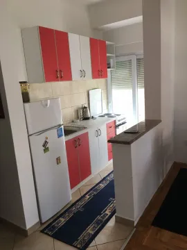 Kitchen with red and white cabinets and a refrigerator. - image 3