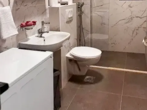 Kupatilo opremljeno umivaonikom, WC šoljom i perilicom veša. - image 7