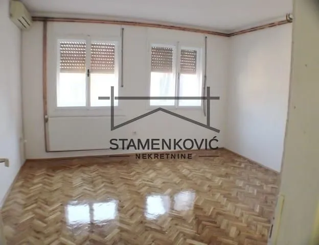 Empty room with parquet flooring and white walls.