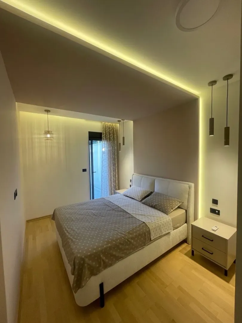 Furnished bedroom with a double bed, nightstands, and modern lighting.