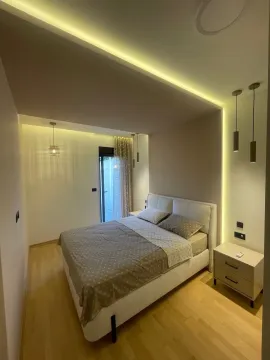 Furnished bedroom with a double bed, nightstands, and modern lighting. - image 4