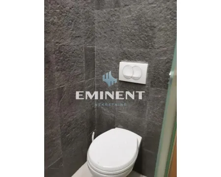 A view of a modernly equipped toilet with dark tiles. - image 7