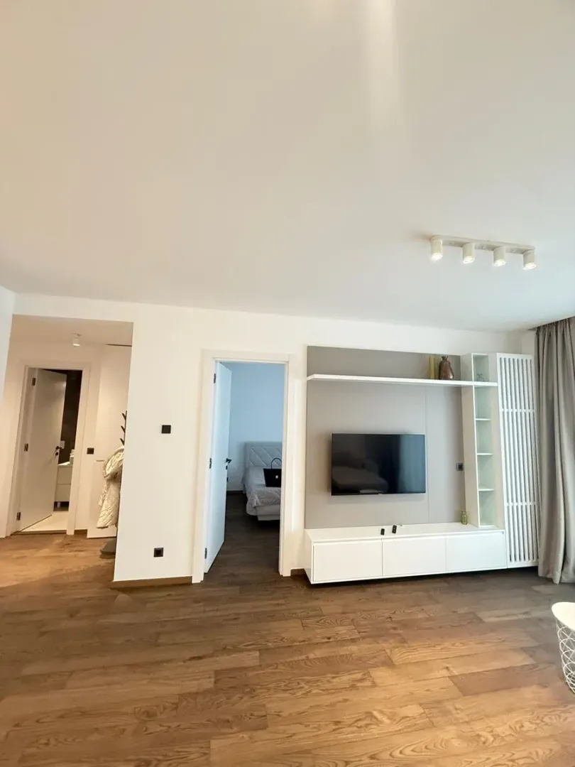 Living room with a TV unit and a view of the hallway and bedroom.