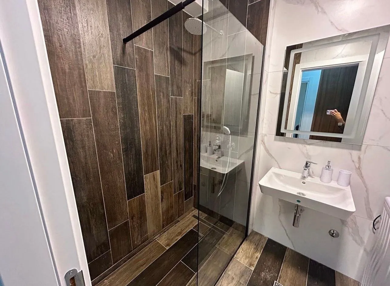 Modern bathroom with a walk-in shower and washbasin.