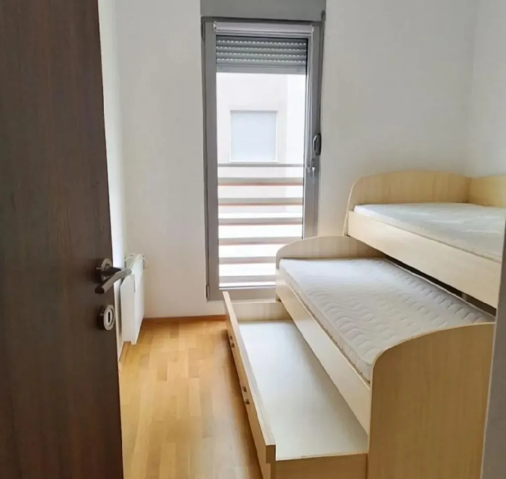 Smaller bedroom with a bunk bed and wooden flooring.