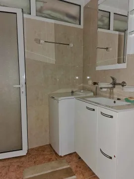 Bathroom with a sink, mirror, vanity cabinet, and washing machine. - image 9