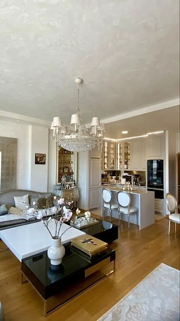 Spacious living room with a dining area and kitchen in the background.