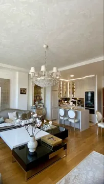 Spacious living room with a dining area and kitchen in the background. - image 2