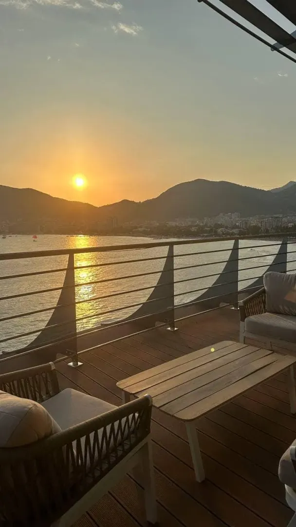 Pogled na zalazak sunca sa terase opremljene baštenskim namještajem.