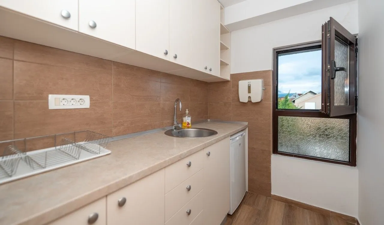 Kitchen with a sink, cabinets, and an open window.