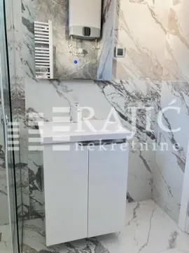Modern bathroom equipped with a white vanity and marble tiles. - image 8