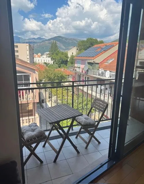 Manji namješteni balkoni sa stolom i dvije stolice sa pogledom na grad i planine.