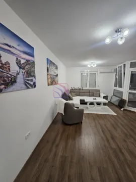 Dnevna soba sa garniturom, stočićem i slikama na zidu. - image 15