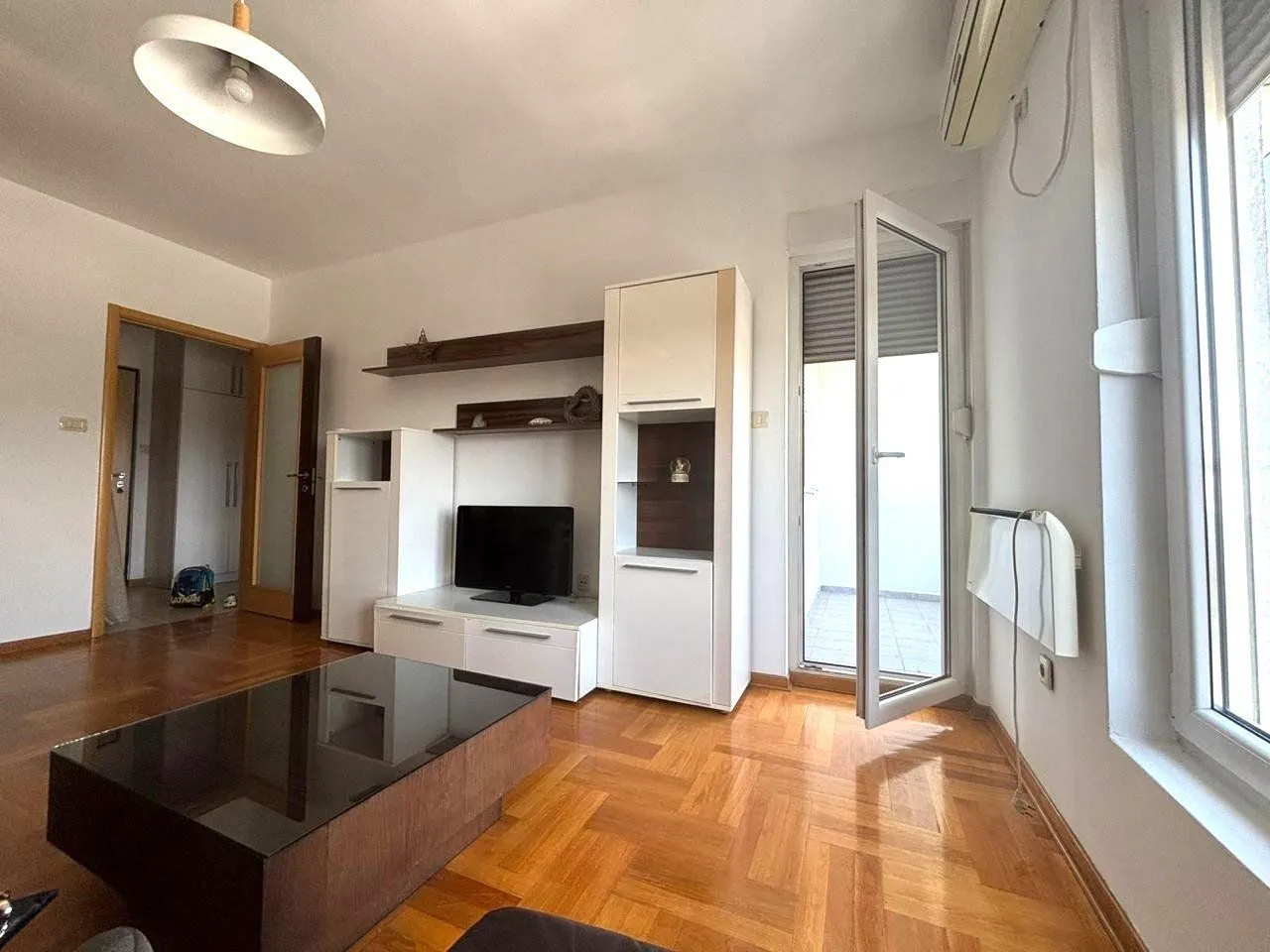 Living room with furniture, TV unit, and access to the terrace.