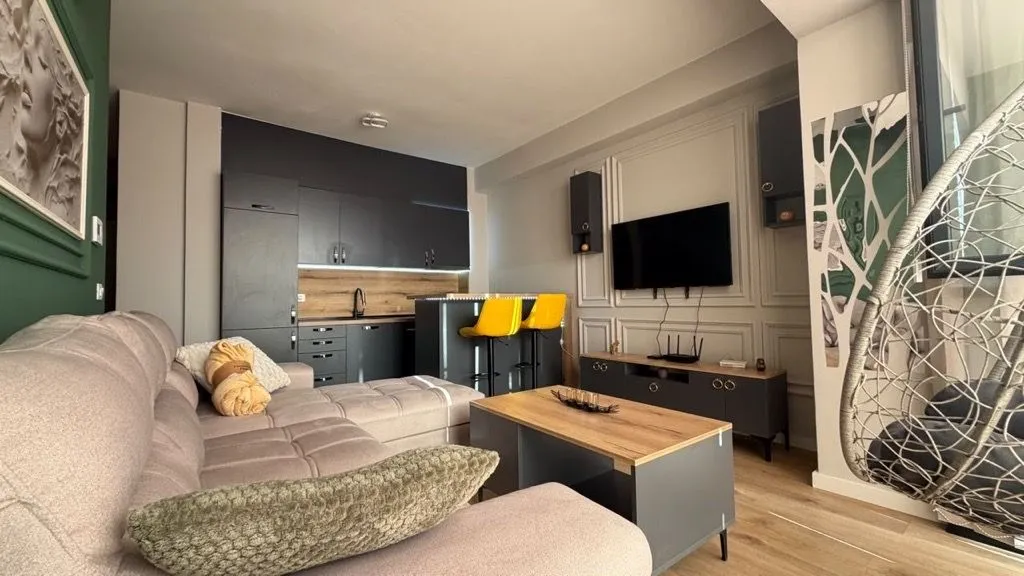 Modern living room with a sofa and a dining area in the background.