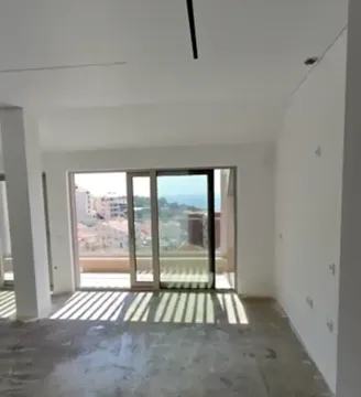 Nepreuređena prostorija u izgradnji sa velikim staklenim otvorom i izlazom na terasu. - image 2