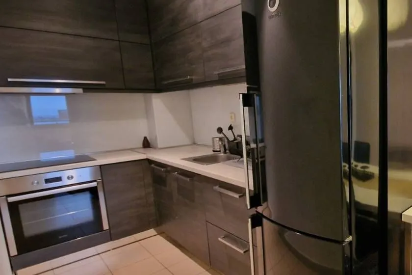 Kitchen equipped with dark cabinetry and built-in appliances.