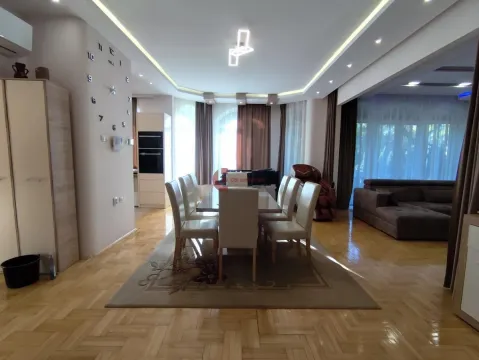 Spacious living room with a dining area and parquet flooring. - image 22