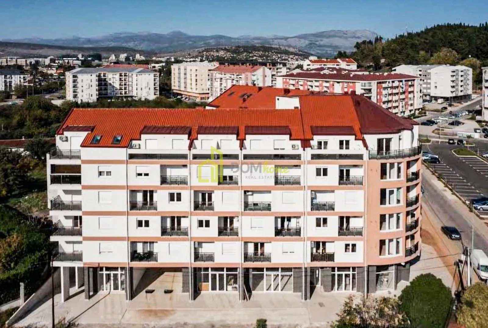Aerial view of the residential building facade and surrounding neighborhood.