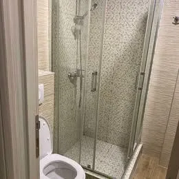 Small bathroom with a shower cabin and toilet. - image 8