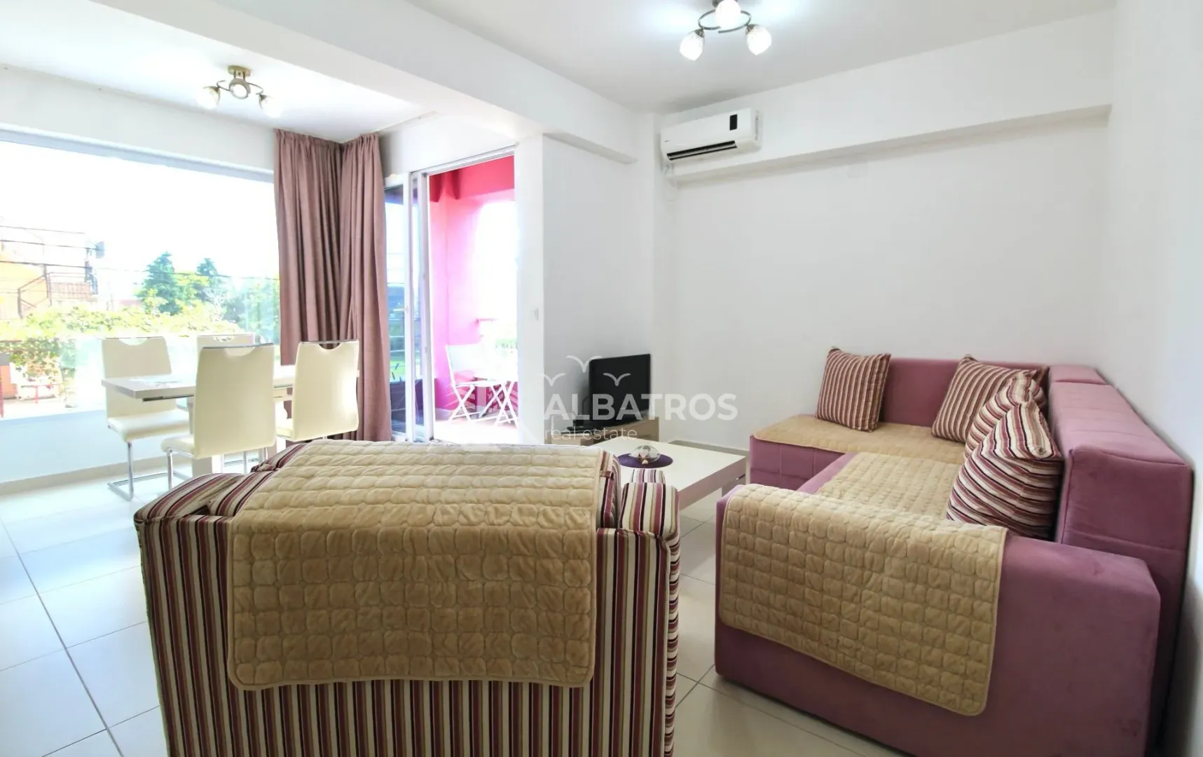 Spacious living room with sofa set, dining area, and access to the terrace.