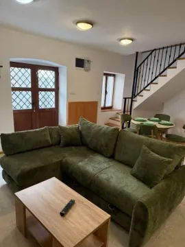 Living room with a sectional sofa, coffee table, and stairs in the background. - image 20