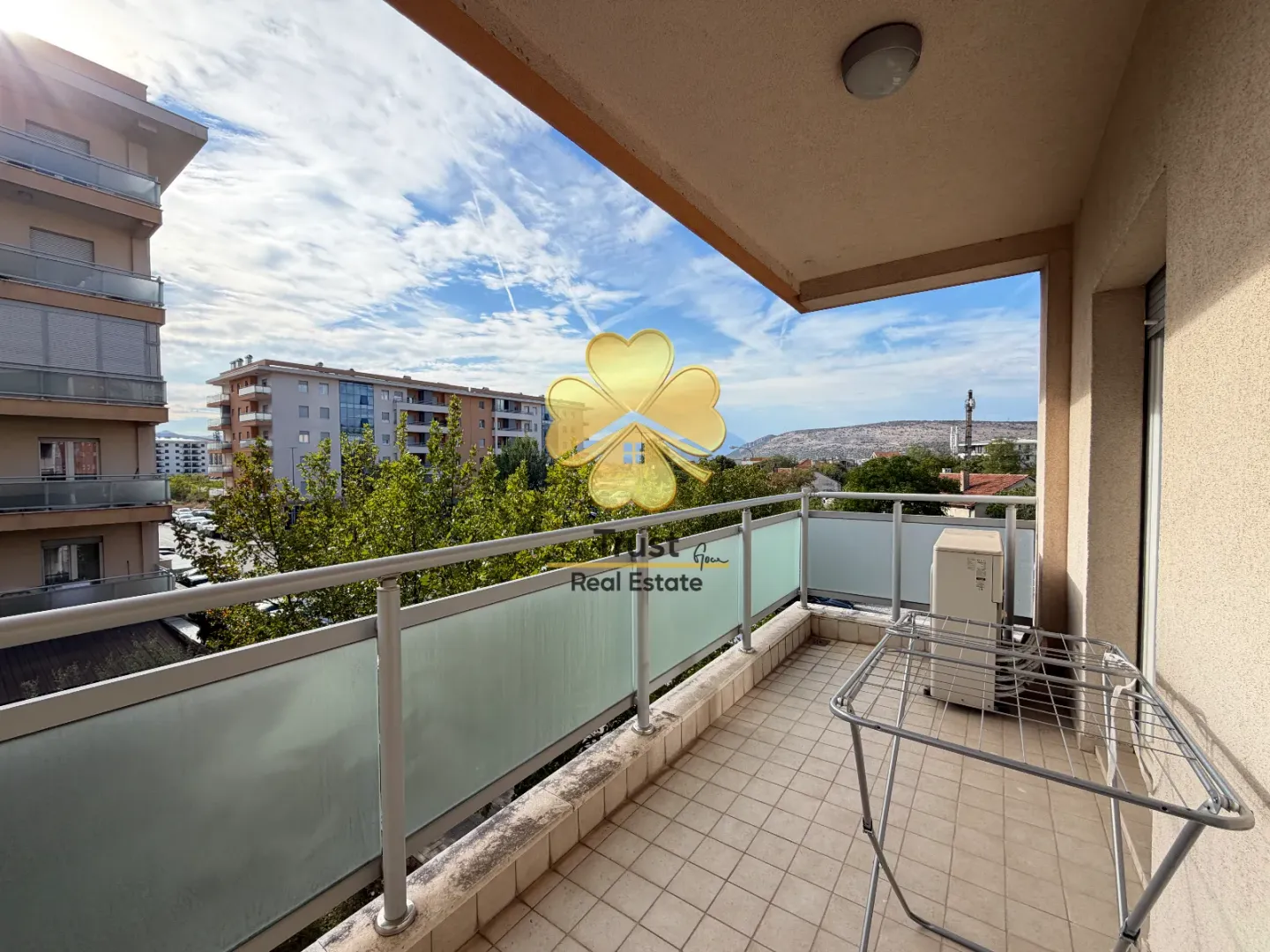 Spacious tiled balcony with a view of the neighborhood and surrounding buildings.