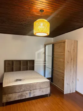 Furnished bedroom with a double bed, wooden ceiling, and a wardrobe. - image 5