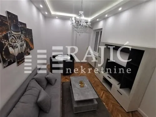 Furnished living room with a sofa and TV unit.
