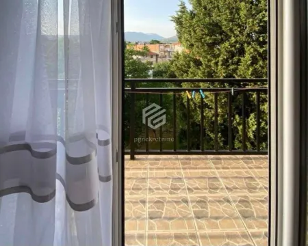 Pogled kroz balkonska vrata na popločanu terasu i zelenilo. - image 2