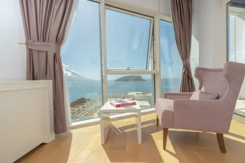 Bright living room with a comfortable armchair and a sea view. - image 20