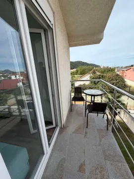 Small furnished balcony with a table and chairs and a view of the surroundings. - image 9