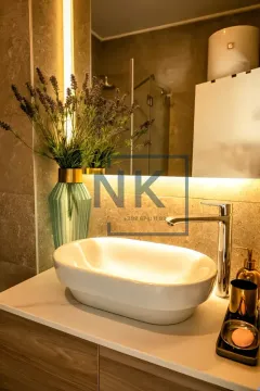 Moderan umivaonik sa slavinom i dekorativnim cvijećem u kupatilu. - image 7