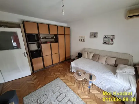 Living room with a sofa, a large wooden wardrobe and parquet flooring. - image 2