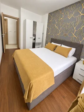 Furnished bedroom with a double bed, white wardrobe, and decorative wallpaper. - image 5