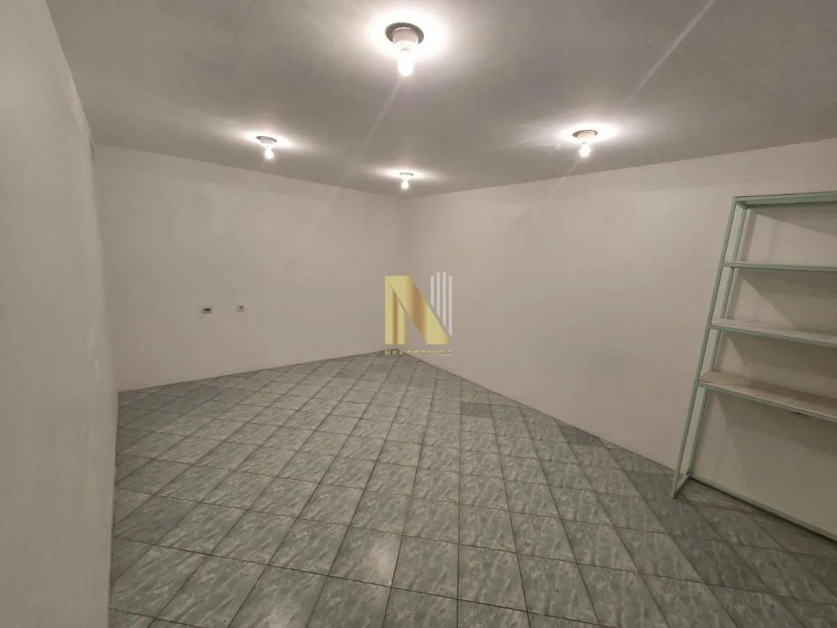 Empty room with floor tiles and a shelving unit.