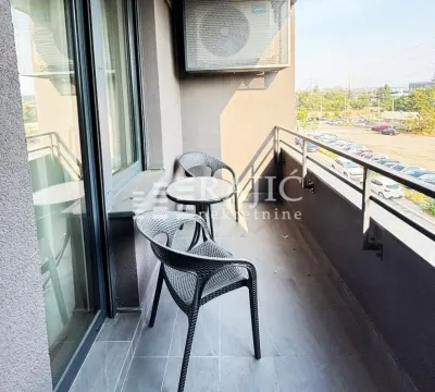 A small furnished balcony with a table and two chairs. - image 11
