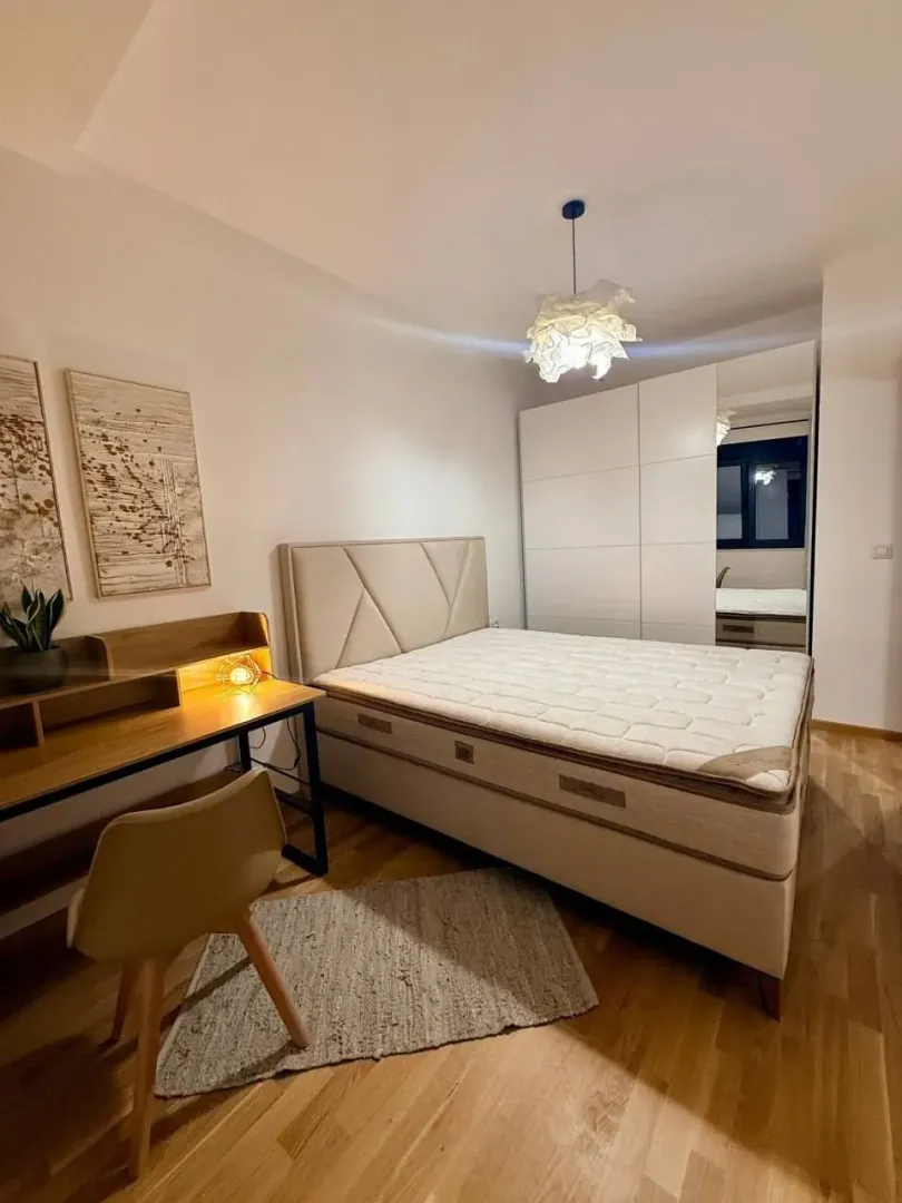Furnished bedroom with a double bed, wardrobe, and a desk.