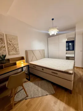 Furnished bedroom with a double bed, wardrobe, and a desk. - image 6