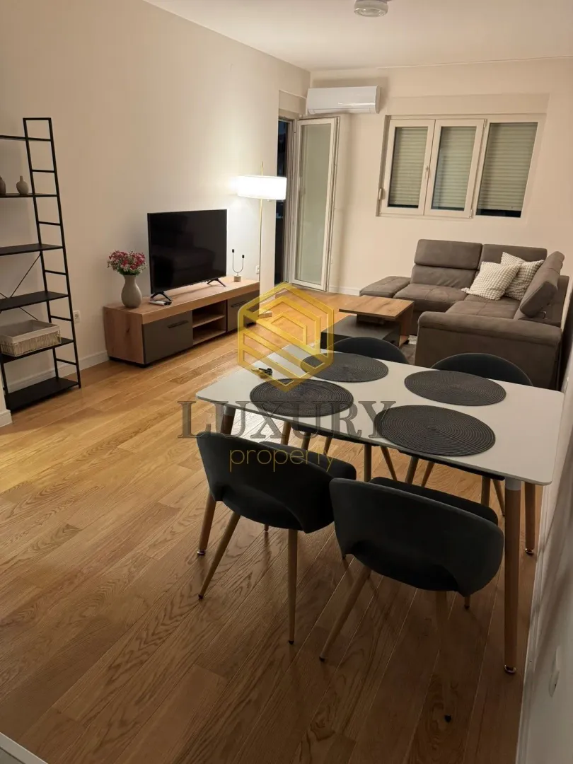 Living room with a dining area, sofa, and television.