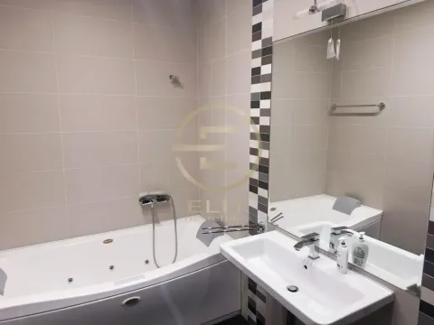 Modern equipped bathroom with a bathtub and a washbasin. - image 10