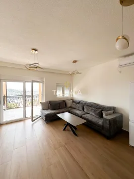 Living room with a sectional sofa, coffee table, and balcony access. - image 5